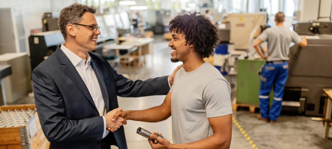 Image of two people smiling and shaking hands